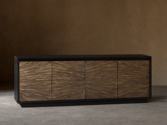 Helios Sideboard with ebony-stained frame and four doors featuring brass sheeting in a sunburst pattern, on wooden floor.