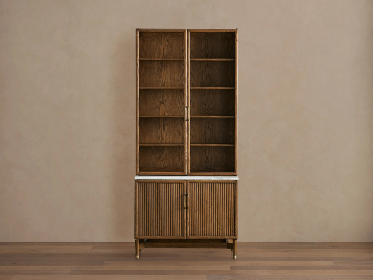 Henderson Cabinet with wood frame in honey finish, black accents, glass doors, adjustable shelves, and Italian Carrara marble top.