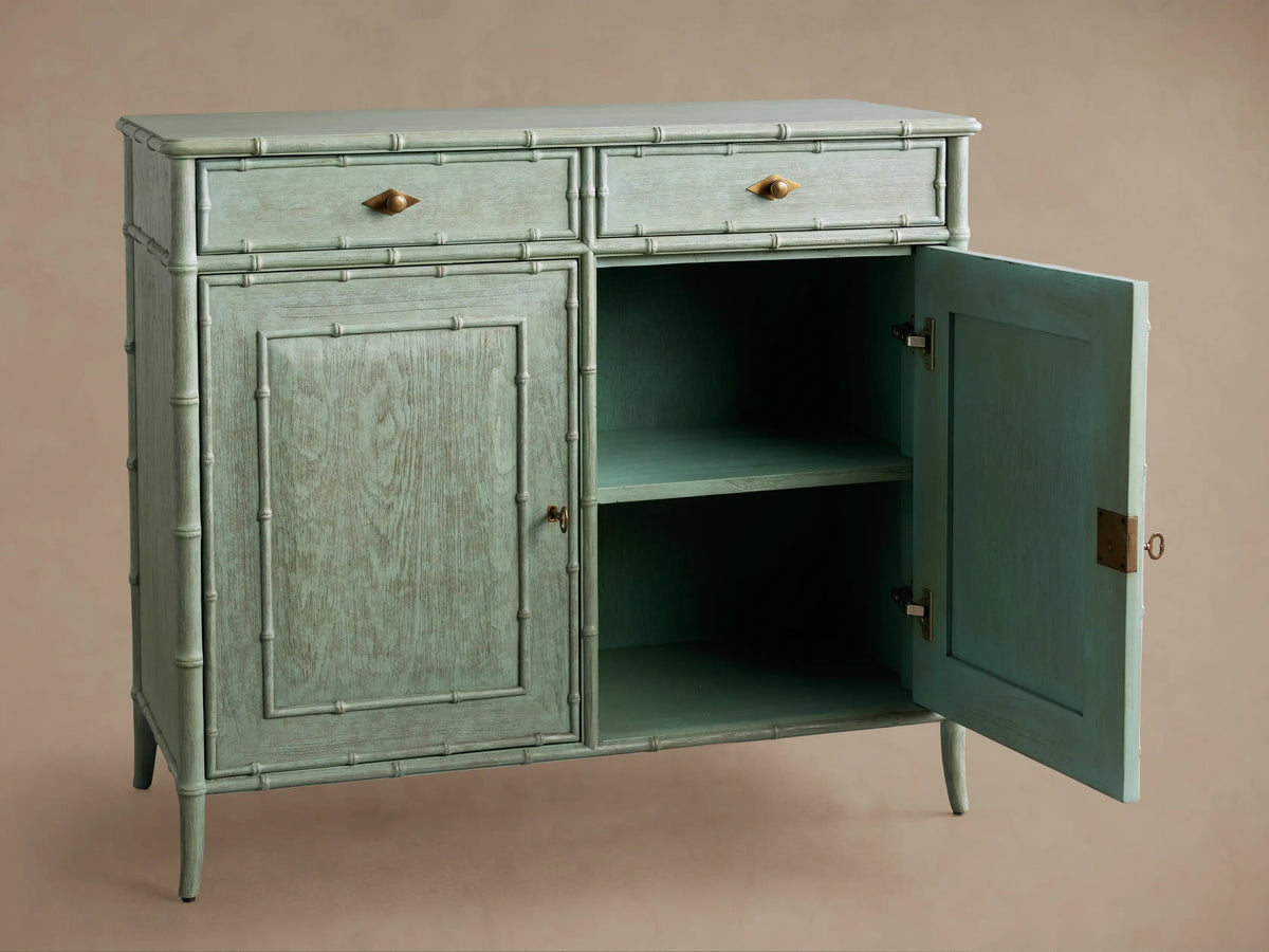 Patinated light green Iris Hall Chest with bamboo framing, two drawers with bronze diamond pulls, and two paneled doors.