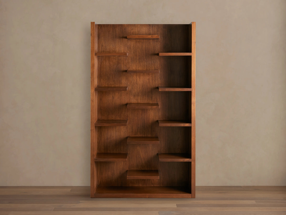 James Bookcase with walnut finish, featuring 13 asymmetrically arranged floating shelves, displayed against a neutral background.