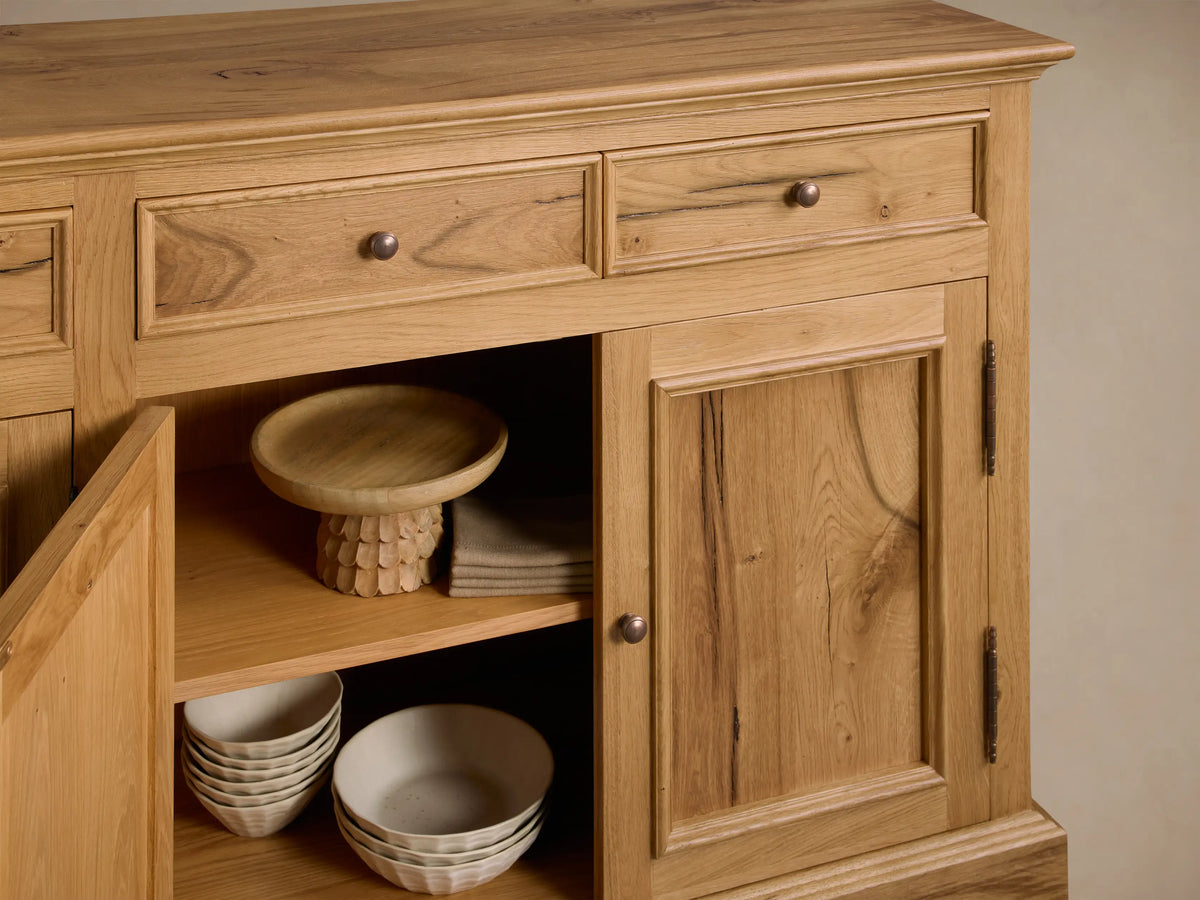 Front view of the light brown Kensington Reclaimed Buffet, with four drawers and two cabinets. One cabinet door open reveals shelves.