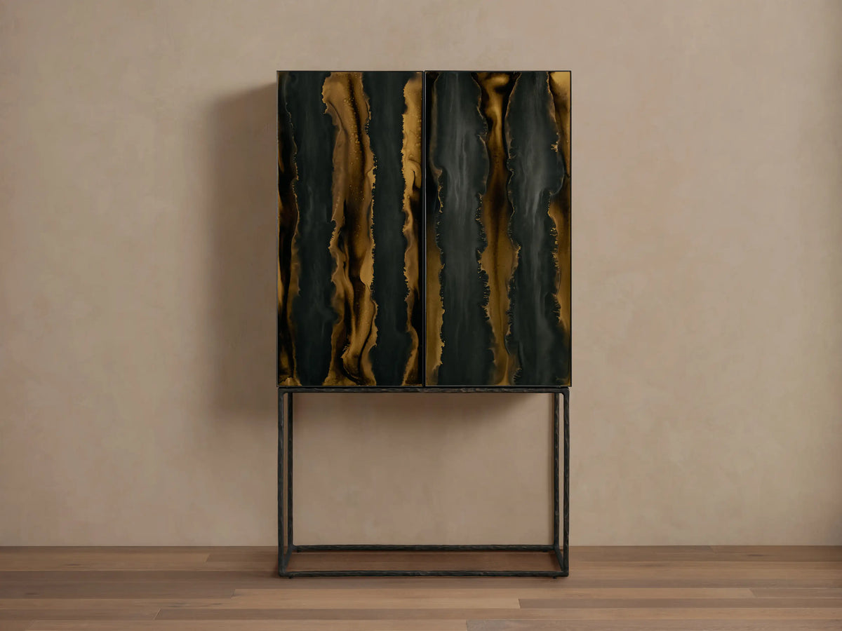 Mareta Bar Cabinet with black and gold marbled vertical wave patterns on doors, standing on a sleek metal base against a neutral wall.