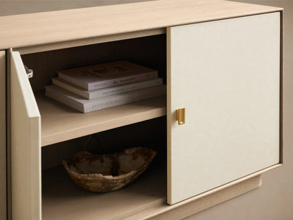 Front view of a light wood and cream sideboard with gold handles; one right door open, revealing two interior shelves.