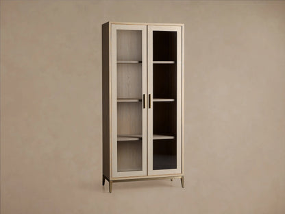 Malone Glass Cabinet: Light oak wood frame, two clear glass doors, brass handles, three shelves, and slender gold legs.