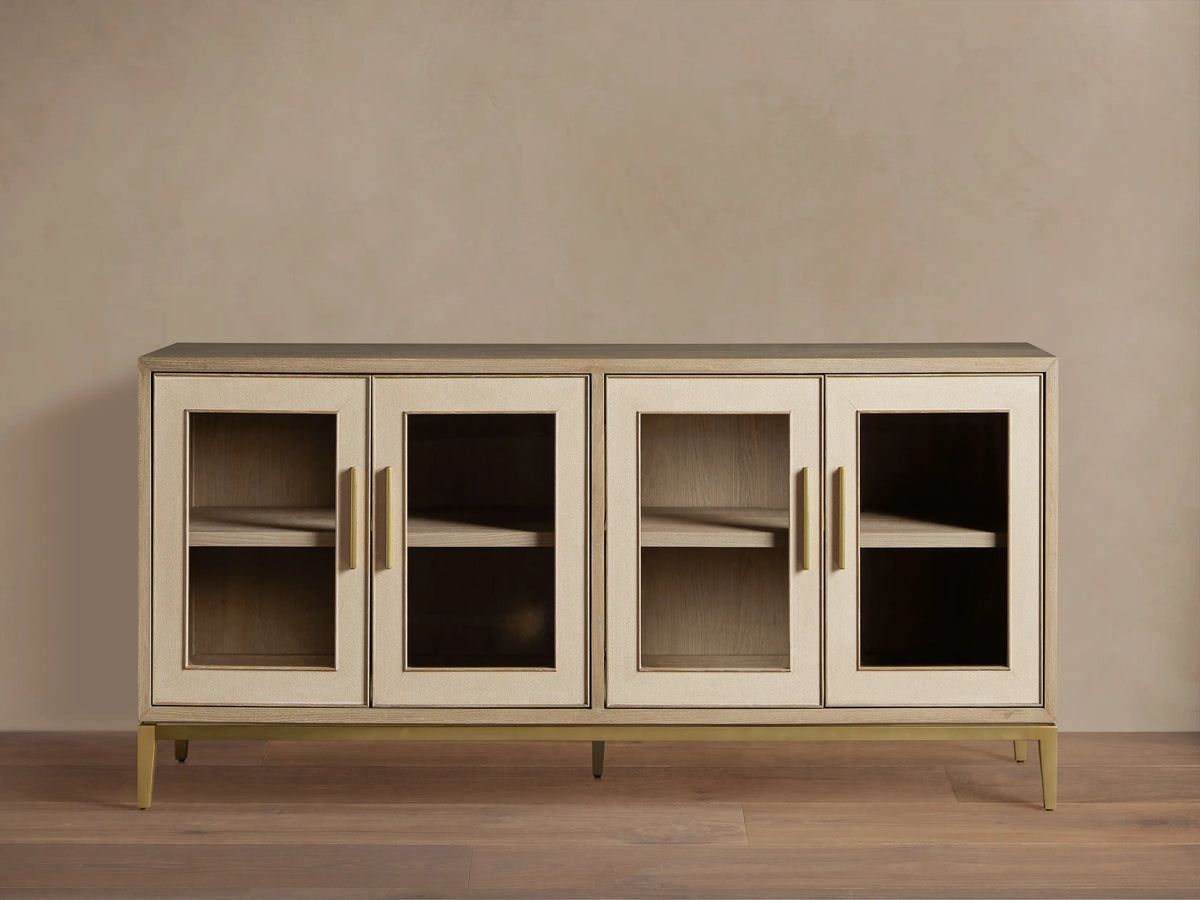Elegant Malone Sideboard in light wood, featuring 4 glass doors with gold bar handles, metallic base, and visible shelves.