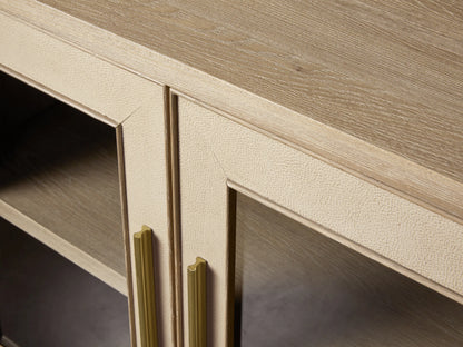 Light wood Malone Sideboard with four glass doors, textured leather insets, metallic gold handles and base.