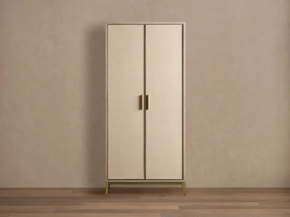 Malone Cabinet: Upright, two light beige doors with textured shagreen, dark trim, brass handles & base on a wooden floor.