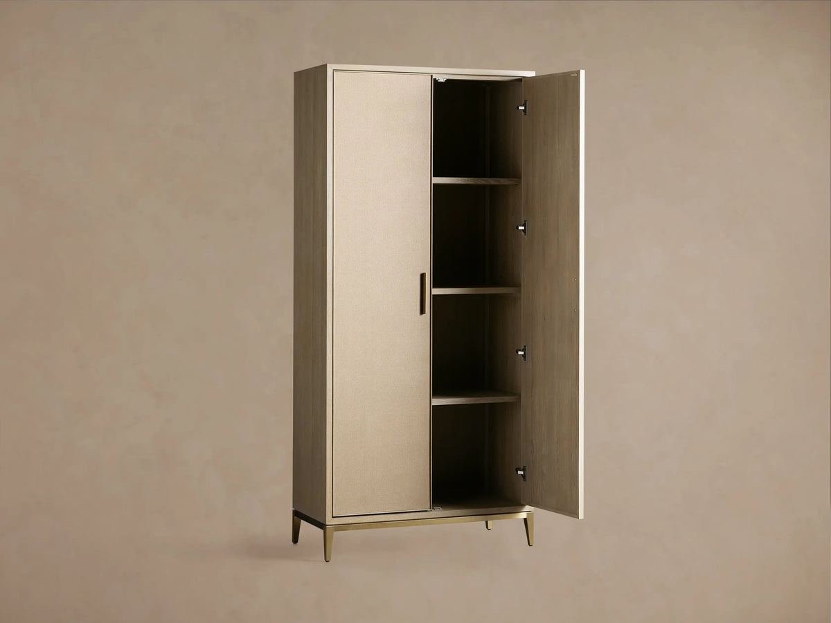 Malone Cabinet in Flemish Natural finish. Tall, two-door cabinet with light textured doors, metallic frame, handles, and base.