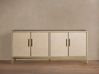 Malone Sideboard in a light shade, featuring four shagreen-textured doors with gold vertical handles, on a matching metallic base.