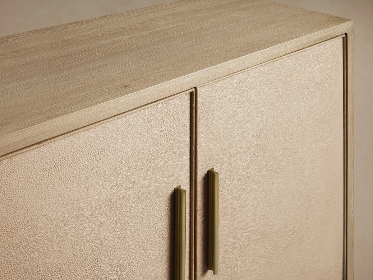 Malone Sideboard with 4 textured shagreen-look doors, vertical gold handles & metallic legs, on a plain background.