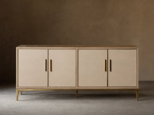 Malone Sideboard in a light shade, featuring four shagreen-textured doors with gold vertical handles, on a matching metallic base.