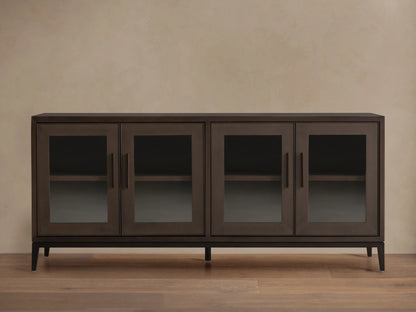 Malone Sideboard in dark walnut, featuring four glass doors, sleek handles, and visible interior shelves, on a wood floor.