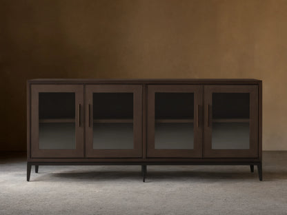 Malone Sideboard in dark walnut, featuring four glass doors, sleek handles, and visible interior shelves, on a wood floor.