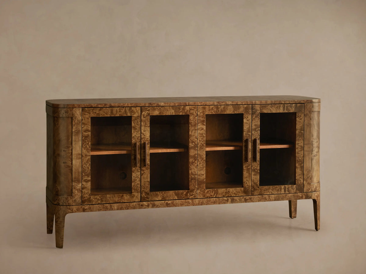 Front view of Mappa burl wood Mogadore Sideboard with four glass doors, antique brass handles, two interior shelves, and tapered legs.