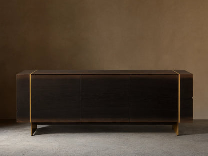 Mihaela Media Console: Dark walnut veneer, three doors, visible wood grain, metallic gold accents, dark angled metal legs.