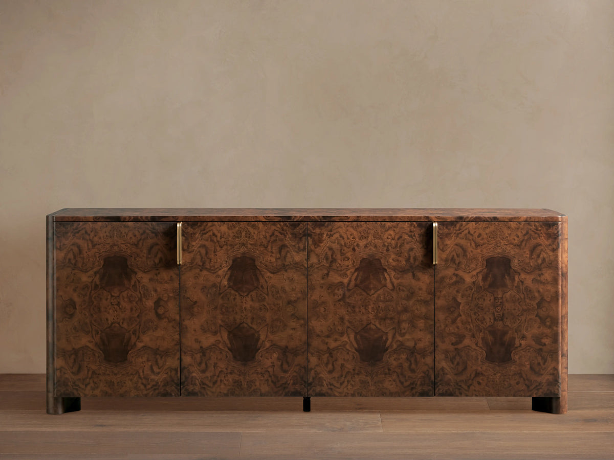 Morley Sideboard with swirling walnut burl wood veneer, auburn tone finish, four cabinet doors, and brass-finished pulls.