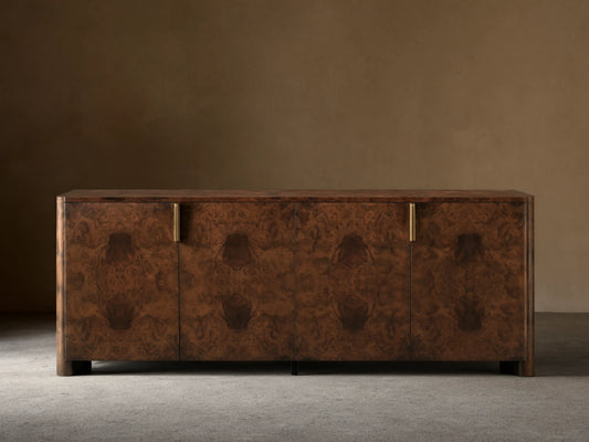Morley Sideboard with swirling walnut burl wood veneer, auburn tone finish, four cabinet doors, and brass-finished pulls.