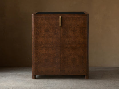 Morley Bar Cabinet with a rich dark brown wood finish, intricate grain pattern, sleek black top, and single vertical handle.