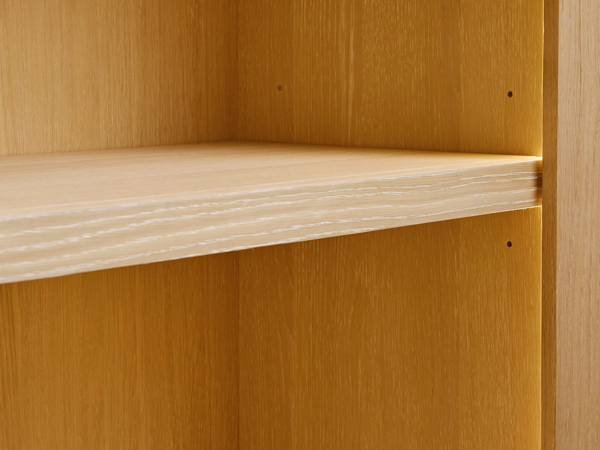 Close-up of a Nason Modular Hutch Cabinet with a light sand-finished white oak shelf, showing visible wood grain and adjustment holes.