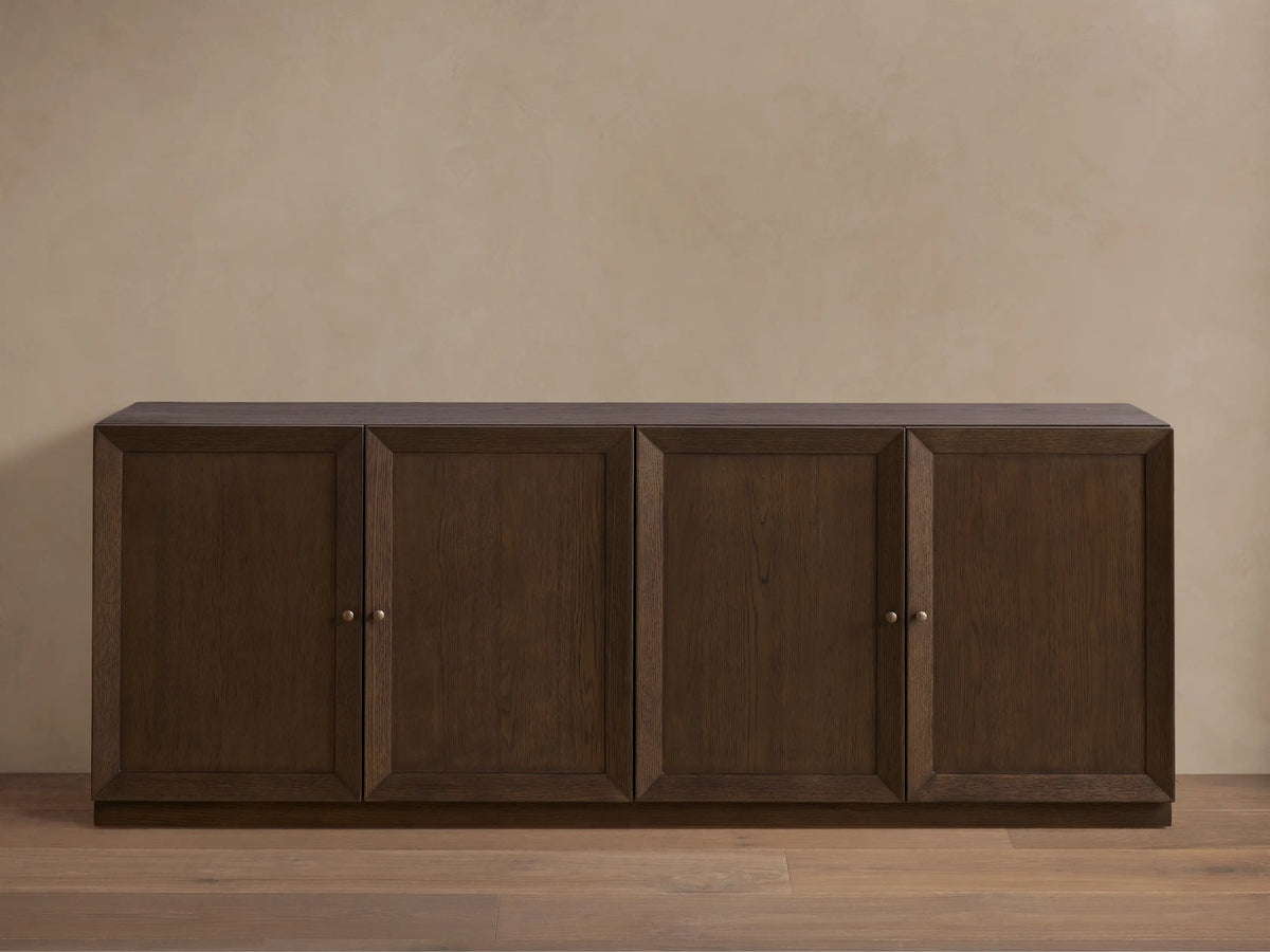 Nason Modular Four-Door Media Base in Mocha finish, featuring four paneled doors with small metal handles, on a wood floor.