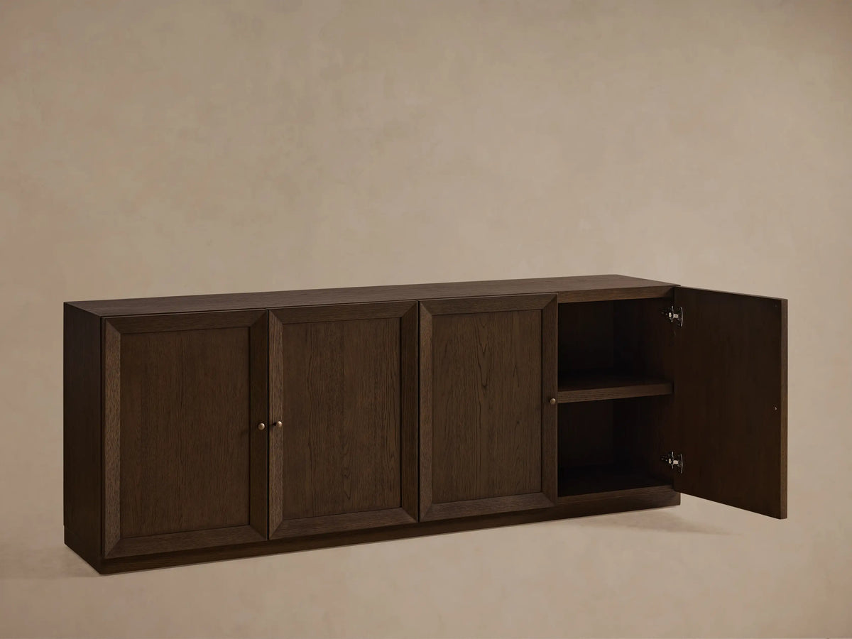 Nason Modular Four-Door Media Base in Mocha finish, featuring four paneled doors with small metal handles, on a wood floor.