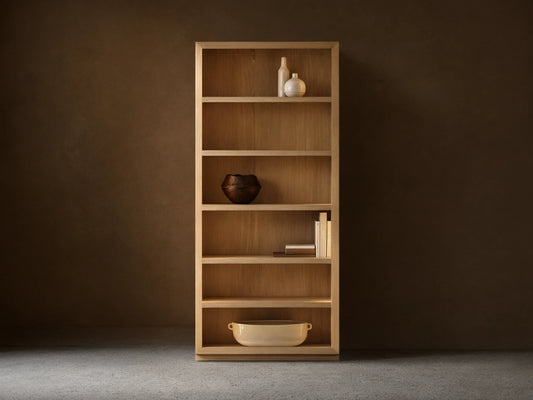 Nason Modular Bookcase in sand white oak, with 6 shelves, recessed LED lighting, and decorative items on display.