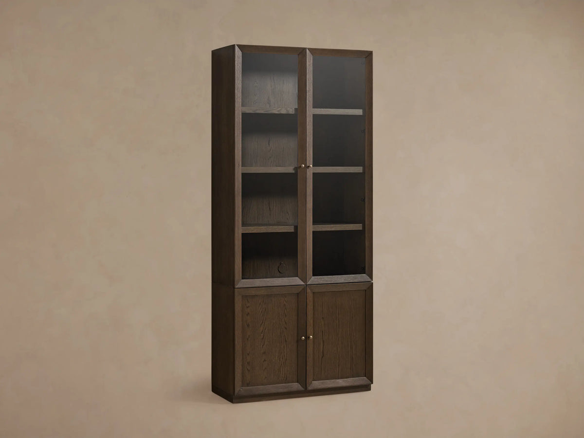 Nason Modular Glass Cabinet in dark Mocha finish. Tall unit with glass display tops, solid doors below, shelves, and decor items.