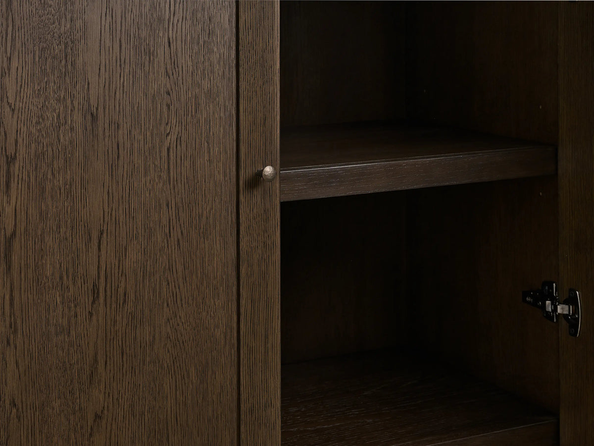 Nason Modular Glass Cabinet close-up. Dark red oak Mocha finish, glass doors, aged nickel handles, lit shelves, and cord management hole.
