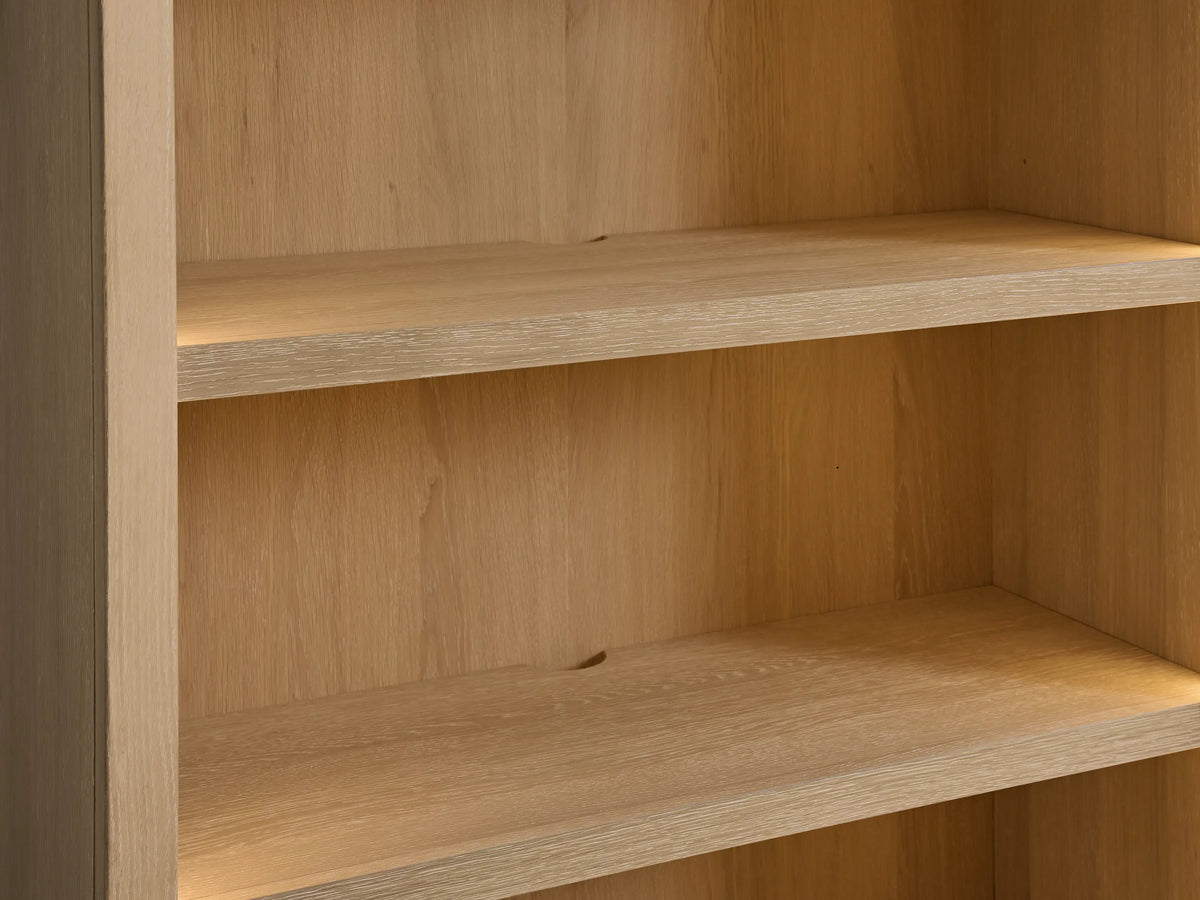 Close-up of Nason Modular Hutch Cabinet's sand white oak shelves with warm under-shelf lighting and a cord management hole.