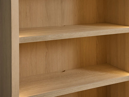 Close-up of Nason Modular Hutch Cabinet's sand white oak shelves with warm under-shelf lighting and a cord management hole.