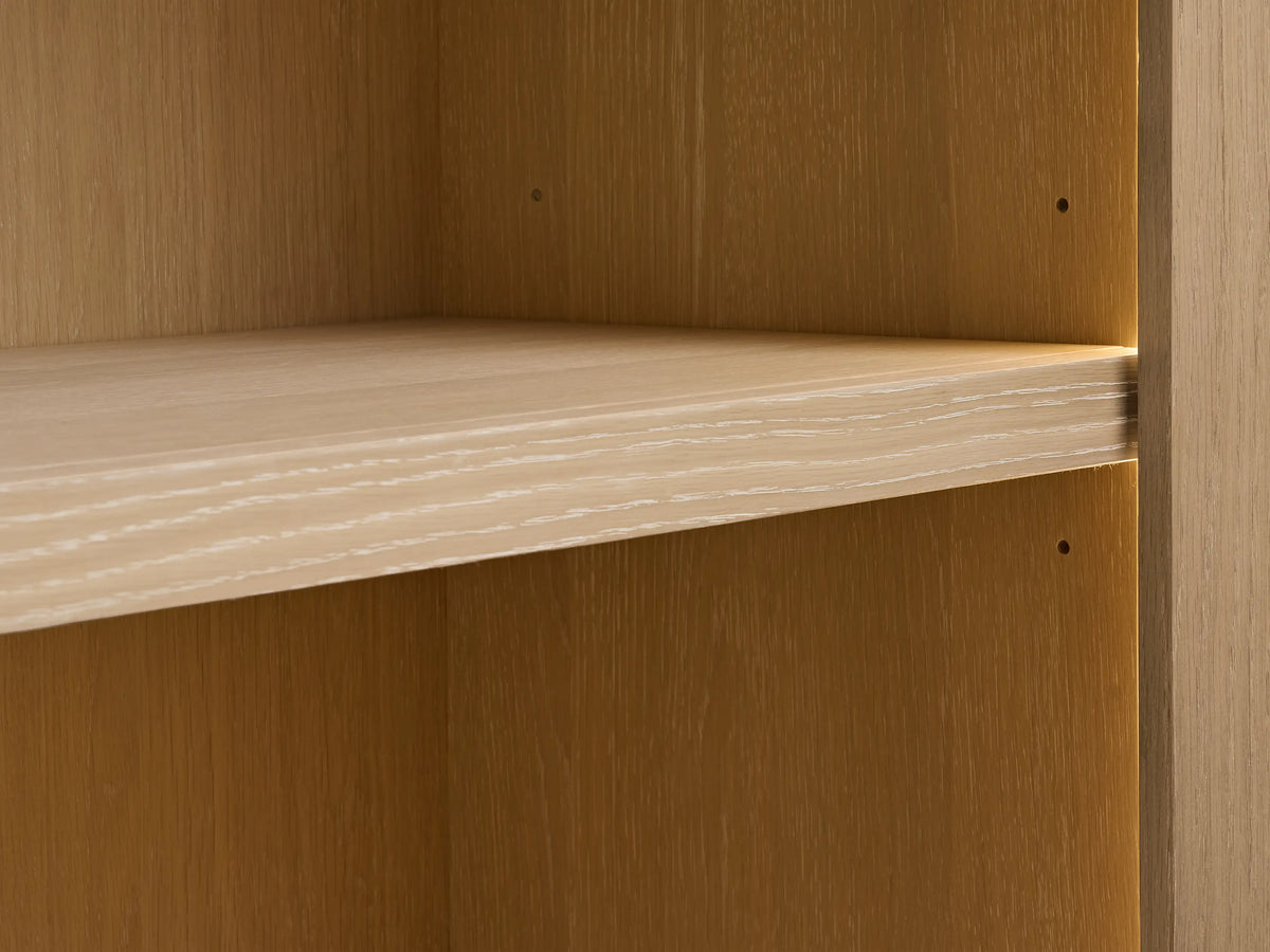 Nason Modular Hutch Cabinet: Close-up of a white oak shelf with sand finish, visible wood grain, and pin holes on panels.