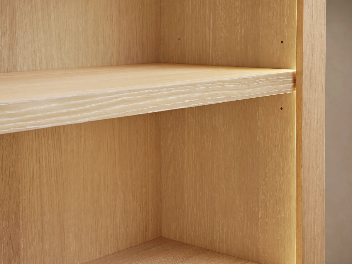 Close-up of Nason Modular Hutch Cabinet's light white oak shelf with visible grain, illuminated by soft warm light from the right.