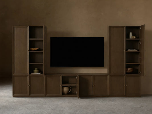 Mocha finished Nason Modular Media Cabinet Set. Dark oak units with framed doors, some open revealing shelves and decor, flanking a TV.