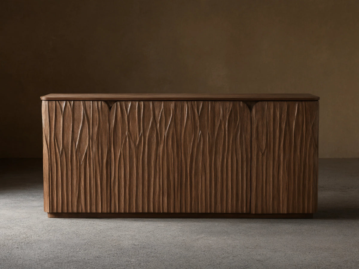 Norris Sideboard: Medium brown wooden sideboard with a flat top and four doors displaying a distinct wavy carved vertical pattern.