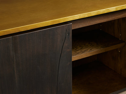 Neira Buffet featuring a rich dark wood front with a subtle grain texture, brass top, and open shelf with warm wood interior.