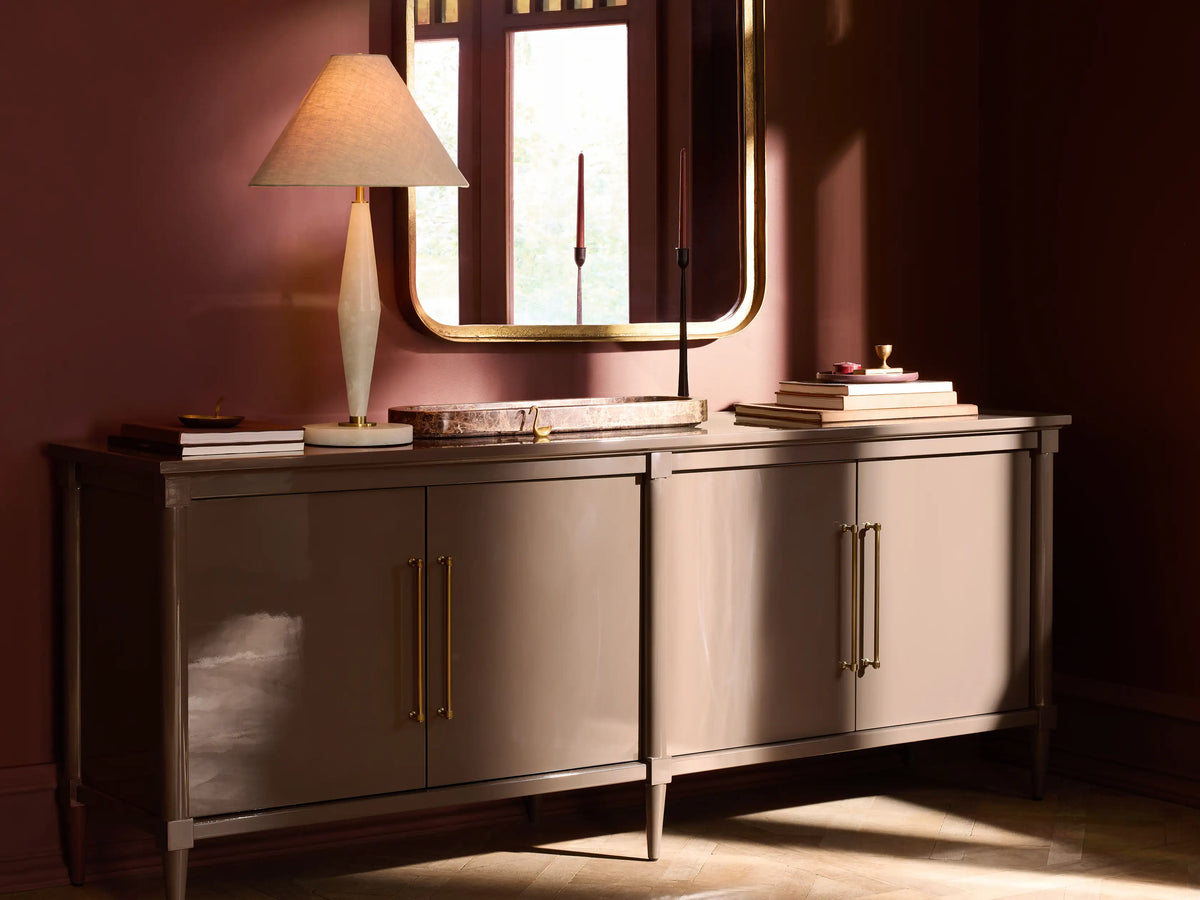 Oakleigh Sideboard in dark finish with brass hardware, four doors, on a wooden floor against a beige wall.