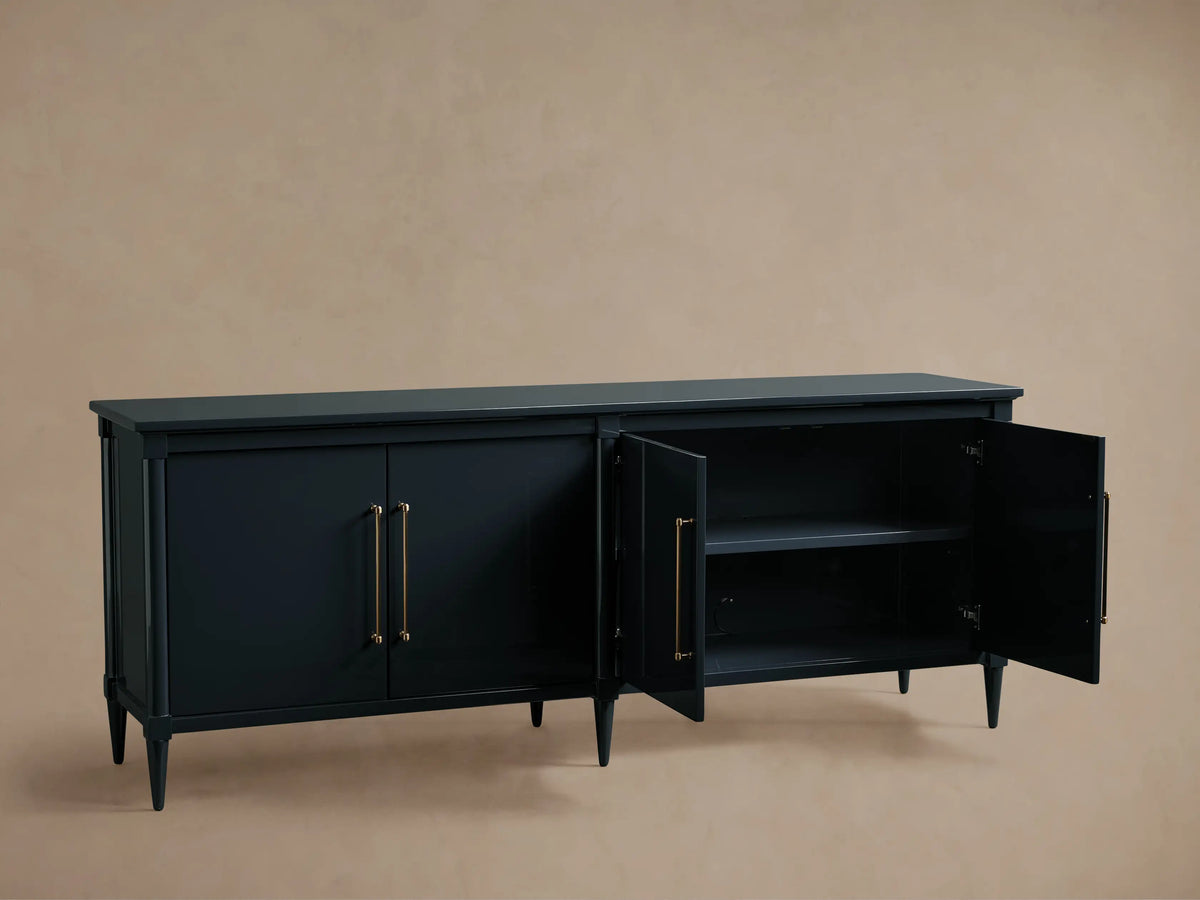 Oakleigh Sideboard made of dark wood with brass hardware, two doors open to show one adjustable shelf, on tapered legs.