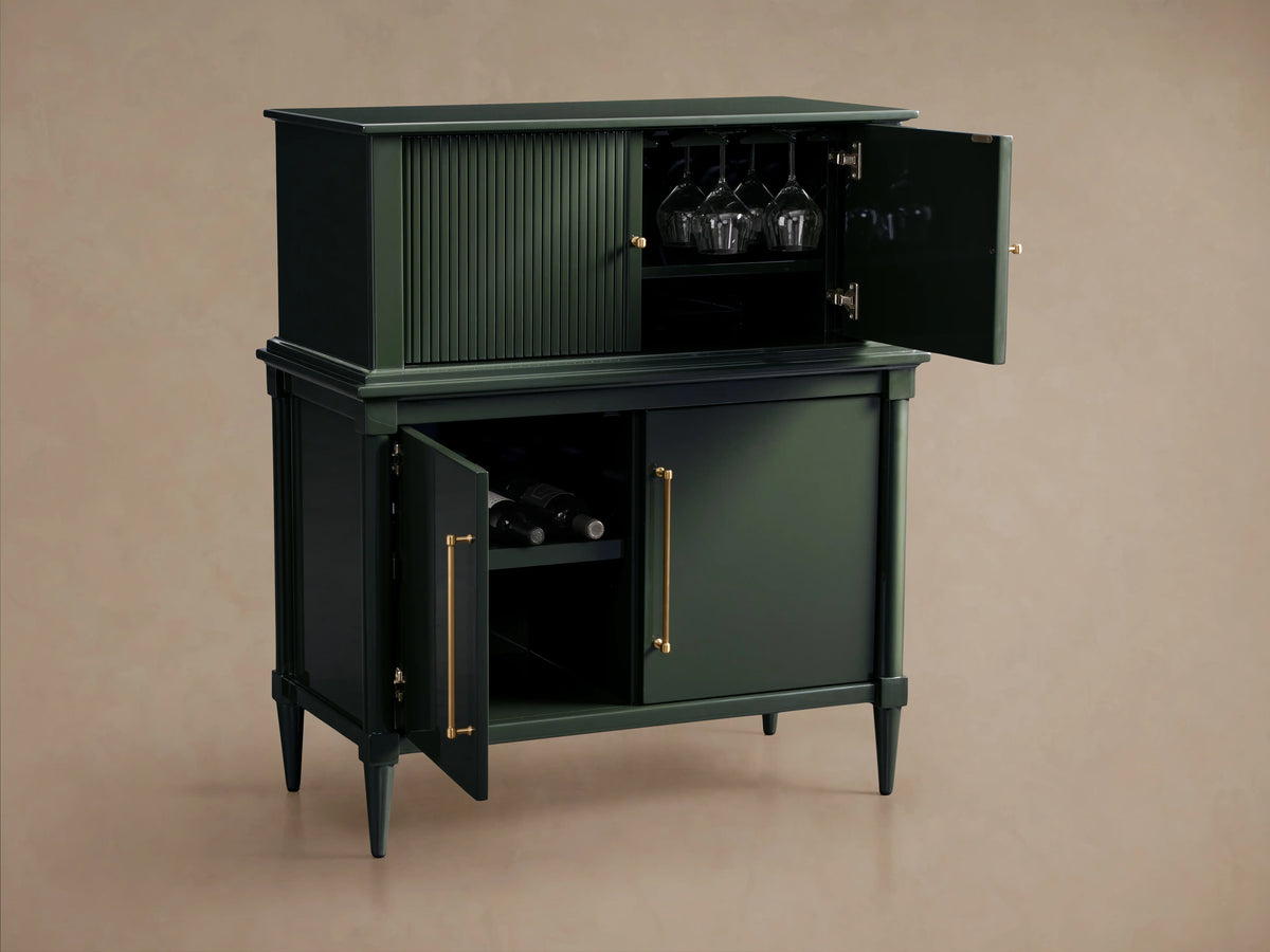 Oakleigh Bar Cabinet in dark green with open doors, revealing stemware and bottle storage. Reeded detailing and brass hardware accent the design.