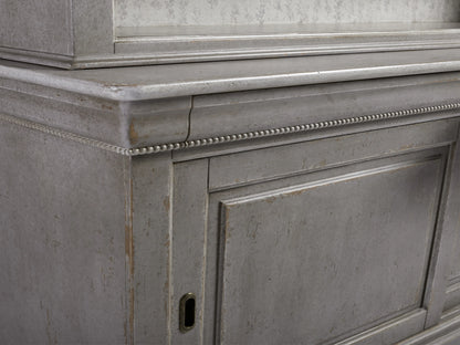 Alt text: Close-up of Giada Bell'Arte Bookcase corner showing hand-applied Antique Grey finish with carved detailing, showcasing its aged look.