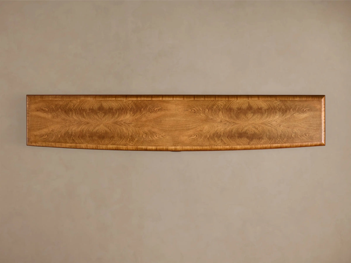 Top view of the Palma Media Console with rich cerajeira wood veneer, showcasing dramatic cathedral graining and curved front.