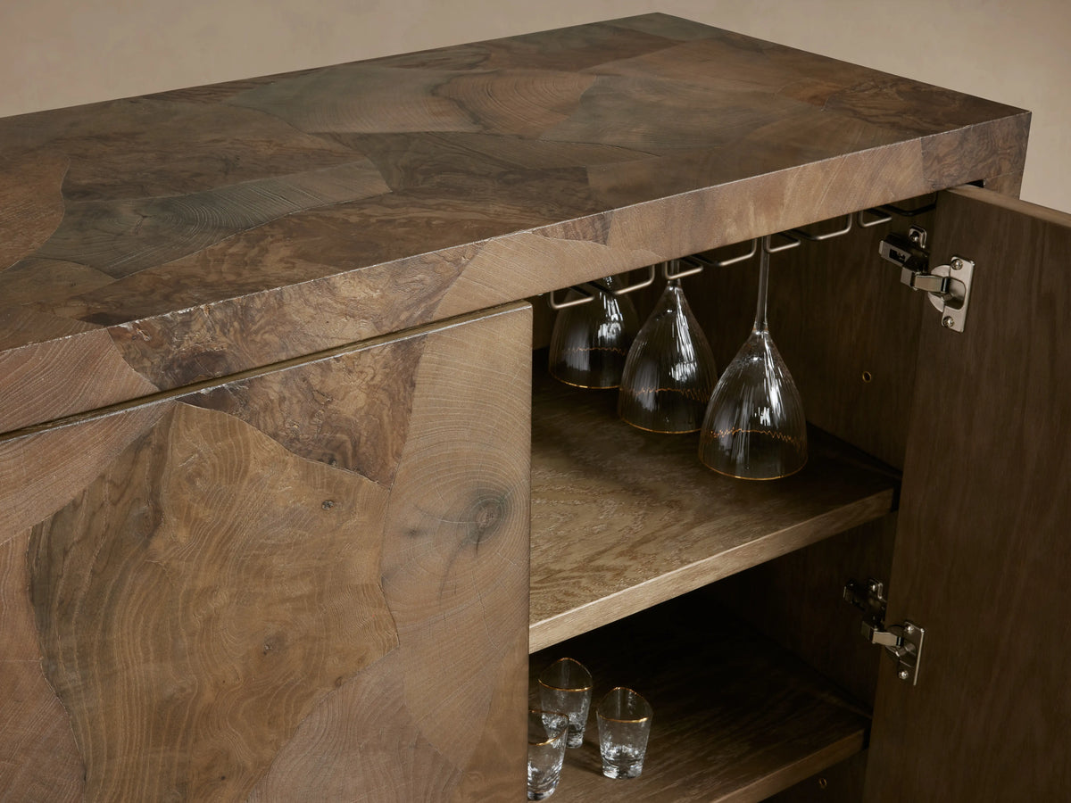 Polanco Bar Cabinet displaying oyster-cut wood pattern, open door showing interior with wine glass holders and shelving.
