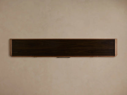 Piermont Sideboard in warm walnut with a smoked glass top, one cabinet door open revealing an interior shelf with books and decor.