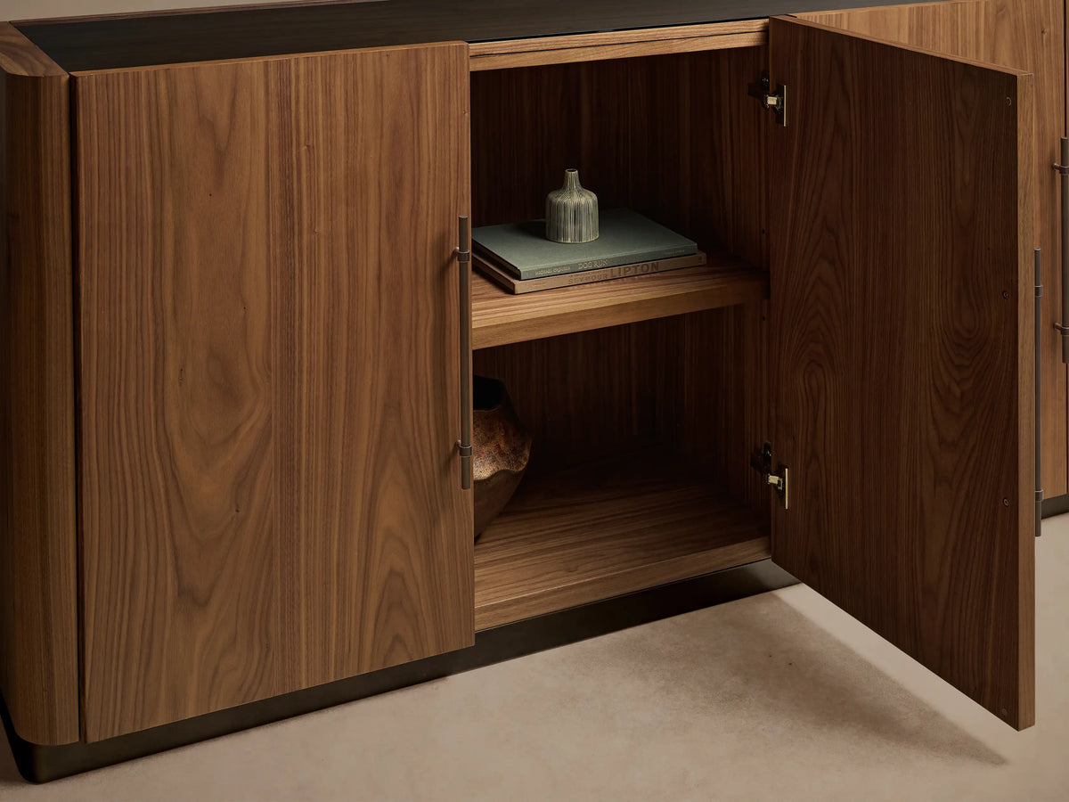 Piermont Sideboard. Horizontal dark walnut wood cabinet with smoked glass top & bronze base. Right door open showing shelves.