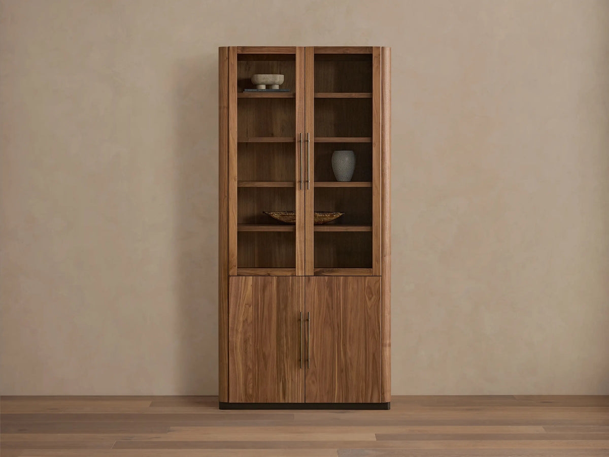 Piermont Modular Glass Cabinet. Dark walnut, two glass doors above two wood doors, bronze handles and base, on a light wood floor.