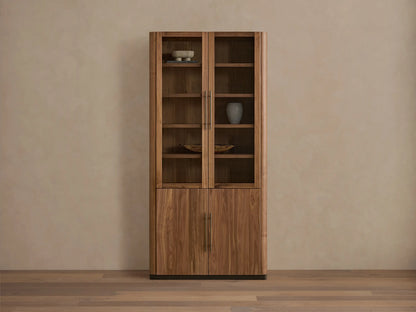 Piermont Modular Glass Cabinet. Dark walnut, two glass doors above two wood doors, bronze handles and base, on a light wood floor.