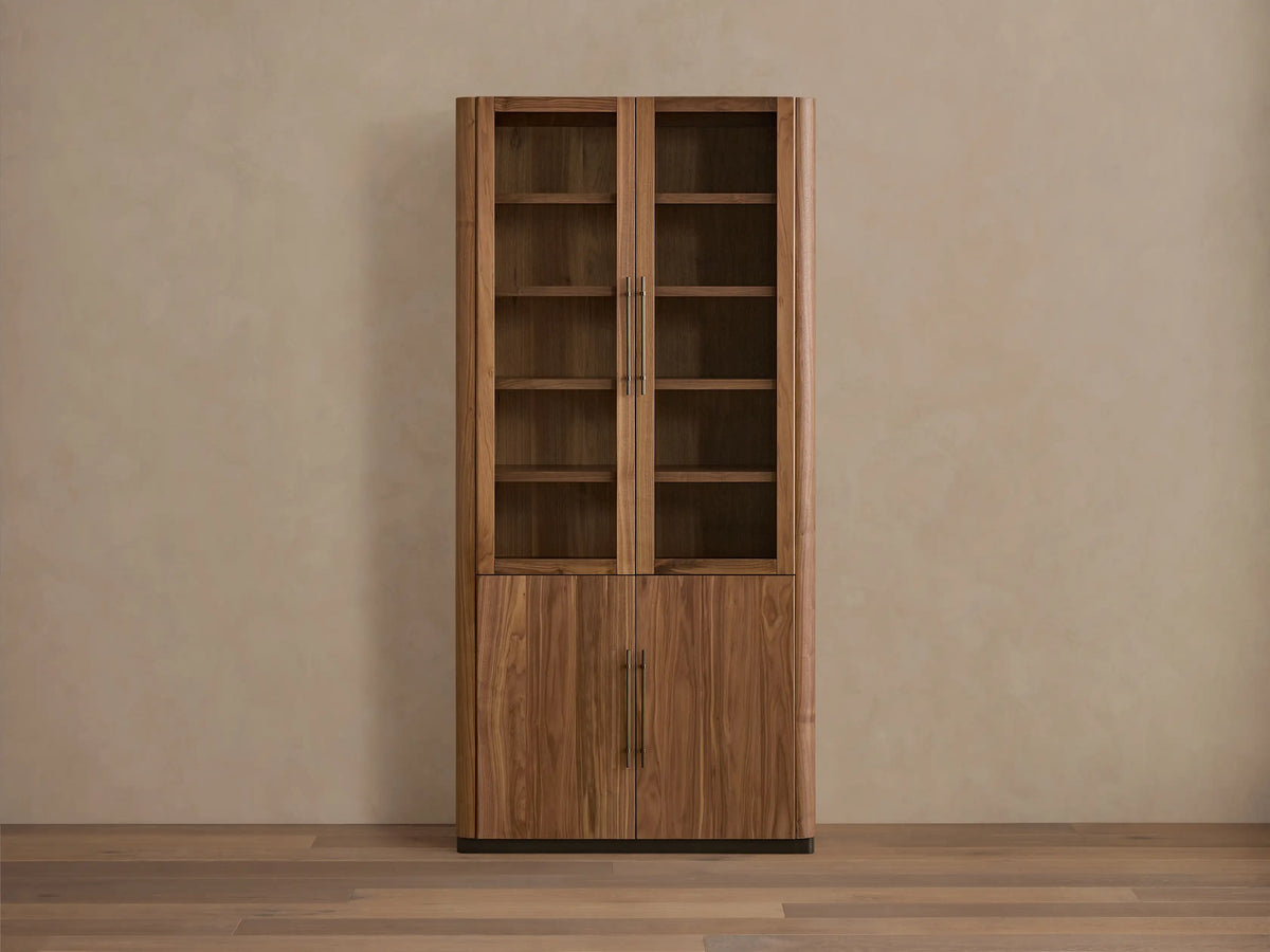Piermont Modular Glass Cabinet. Dark walnut, two glass doors above two wood doors, bronze handles and base, on a light wood floor.