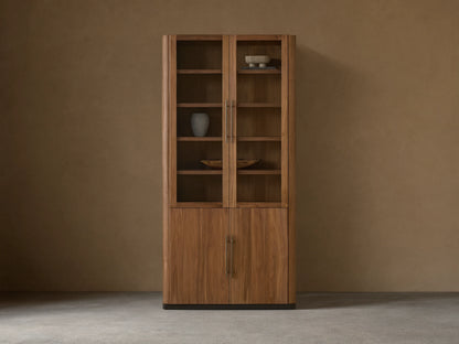 Piermont Modular Glass Cabinet. Dark walnut, two glass doors above two wood doors, bronze handles and base, on a light wood floor.