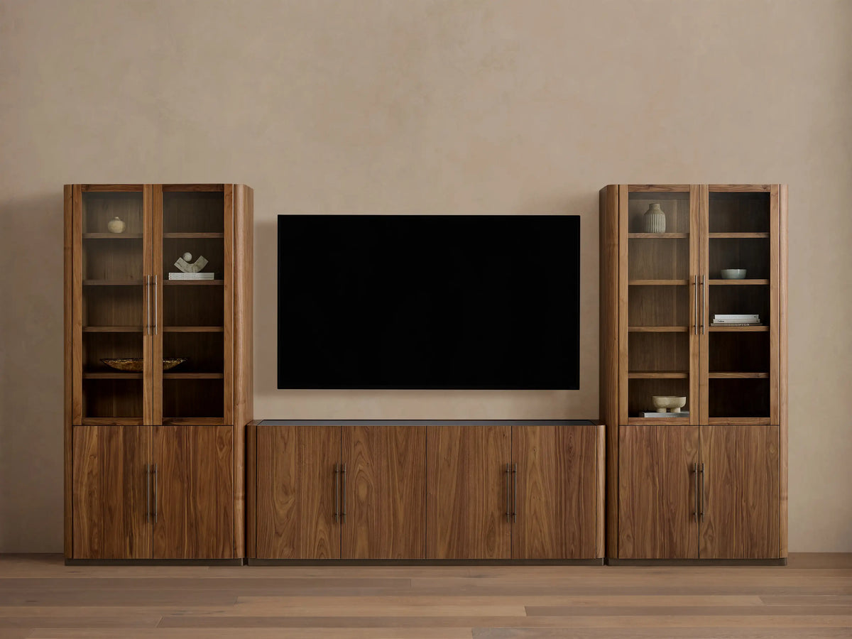 Piermont Modular Glass Media Cabinet Set: dark walnut wood console under TV, flanked by two tall glass-door display cabinets.