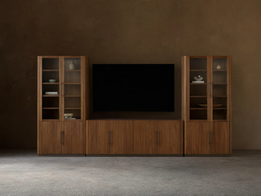 Piermont Modular Glass Media Cabinet Set: dark walnut wood console under TV, flanked by two tall glass-door display cabinets.