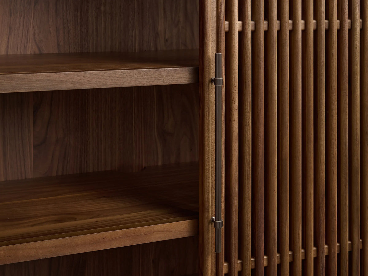 Close-up of Piermont Modular Reeded Cabinet. Dark walnut with reeded top, door open revealing shelves, bronze handle.